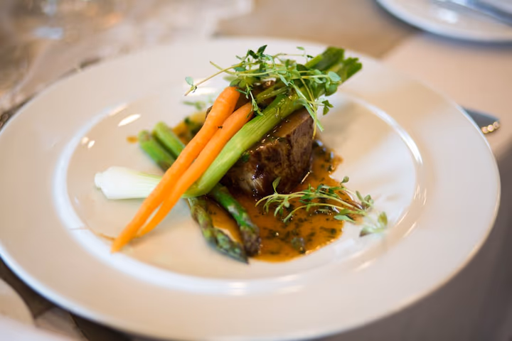 Assiette gastronomique élégante avec légumes et sauce, cuisine raffinée de restaurant.